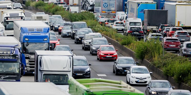 Autos und Lkw stauen sich auf der A3 im Autobahndreieck Köln-Heumar. Nach dem letzten Schultag vor den Sommerferien fahren viele Familien in den Sommerurlaub. - Foto: Rolf Vennenbernd/dpa