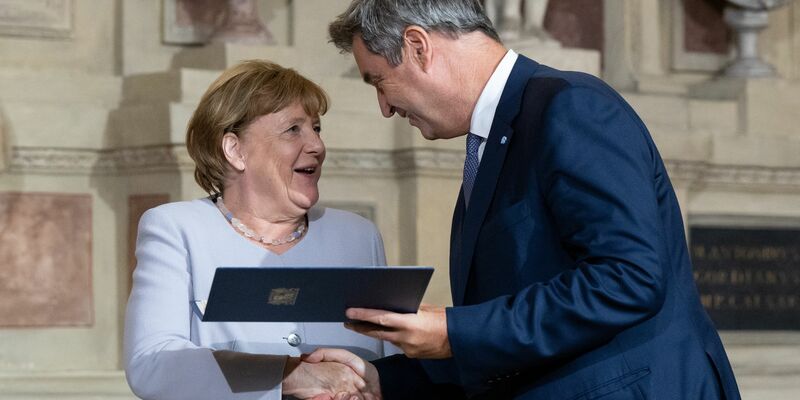 Markus Söder (CSU), Ministerpräsident von Bayern, verleiht Angela Merkel (CDU) den Bayerischen Verdienstorden. - Foto: Sven Hoppe/dpa
