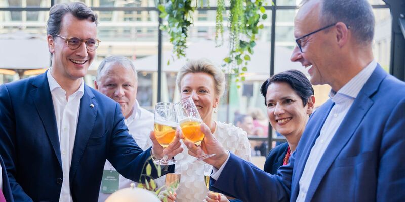 Prost: NRW-Ministerpräsident Hendrik Wüst (l) und CDU-Chef Friedrich Merz stoßen mit einem Bier an. - Foto: Christoph Soeder/dpa
