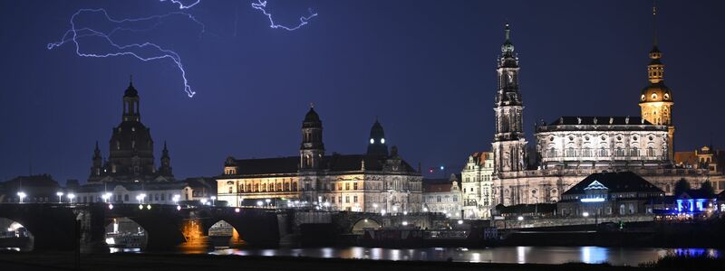 Blitze entladen sich während eines Gewitters am Abend über der Dresdener Altstadt. - Foto: Robert Michael/dpa