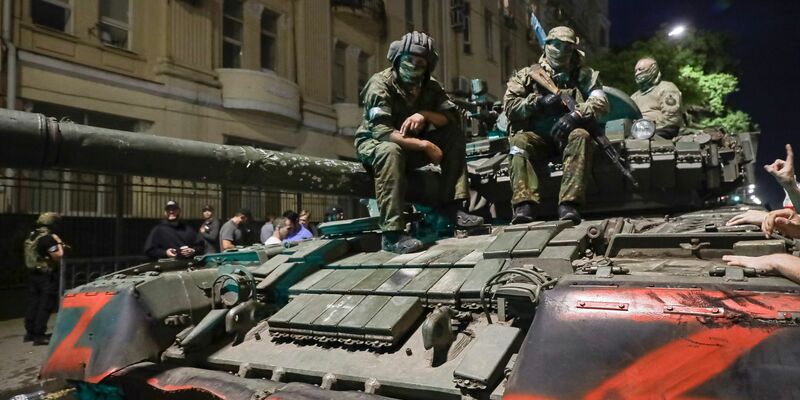 Angehörige des Militärunternehmens Wagner Group sitzen auf einem Panzer auf einer Straße in Rostow am Don, Russland, bevor sie einen Bereich im Hauptquartier des südlichen Militärbezirks verlassen. - Foto: -/AP/dpa