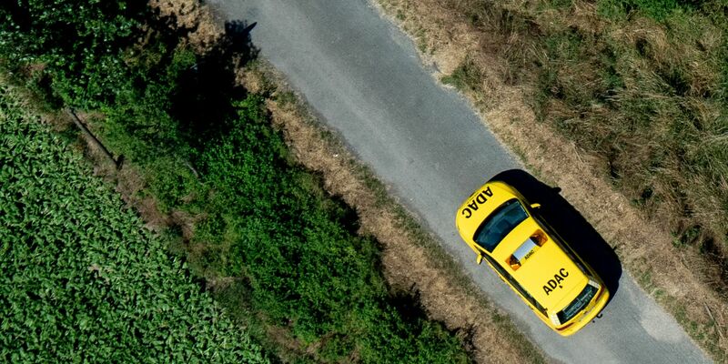 Ein Fahrzeug der ADAC Pannenhilfe fährt über einen Feldweg. - Foto: Hauke-Christian Dittrich/dpa