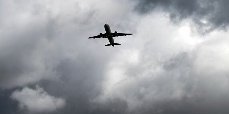 Gewitterwolken türmen sich über einem Flugzeug auf. - Foto: Federico Gambarini/dpa
