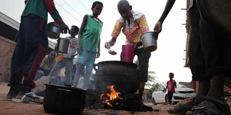 Menschen bereiten in einem Viertel von Khartum Essen zu. Im Sudan soll eine Waffenpause gelten. - Foto: -/AP/dpa