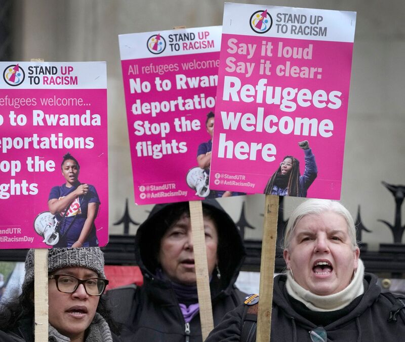 «Stand Up To Racism»-Aktivisten mit Plakaten vor dem High Court in London (Archivbild). - Foto: Kirsty Wigglesworth/AP/dpa