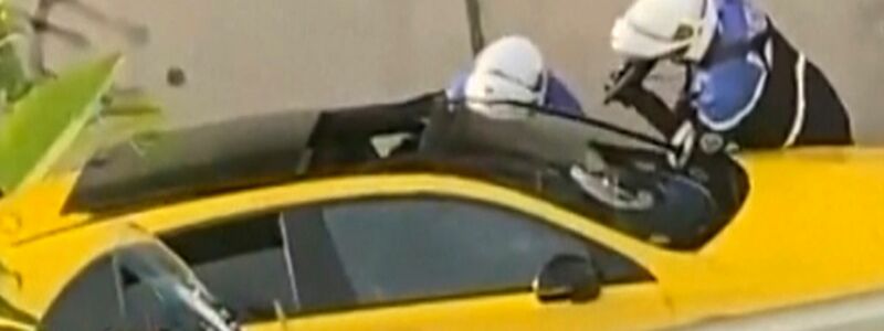 Tödliche Verkehrskontrolle: Zwei Polizeibeamte befragen einen Fahrer, wobei ein Polizist eine Waffe auf das Fenster des gelben Autos richtet. - Foto: @Ohana_FNG/AP/dpa