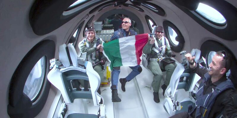 Für einen kurzen Zeitraum durften die drei italienischen Wissenschaftler ihre Sitzplätze verlassen, erlebten Schwerelosigkeit und rollten eine italienische Flagge aus. - Foto: Uncredited/Virgin Galactic/AP/dpa