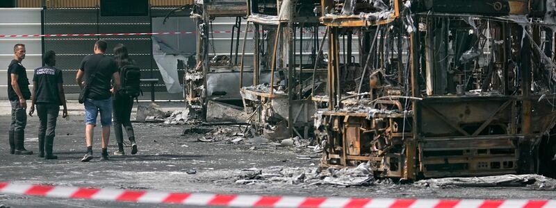 Polizeiermittler vor ausgebrannten Bussen in Aubervilliers. - Foto: Michel Euler/AP/dpa