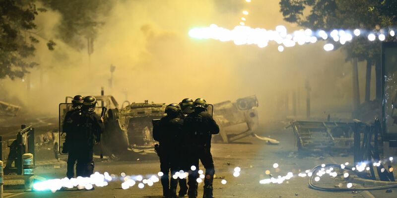 Beamte der Bereitschaftspolizei patrouillieren bei Unruhen auf einer Straße in Nanterre. - Foto: Aurelien Morissard/AP/dpa