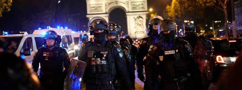 Polizisten patrouillieren vor dem Arc de Triomphe auf der Champs Élysées. - Foto: Christophe Ena/AP