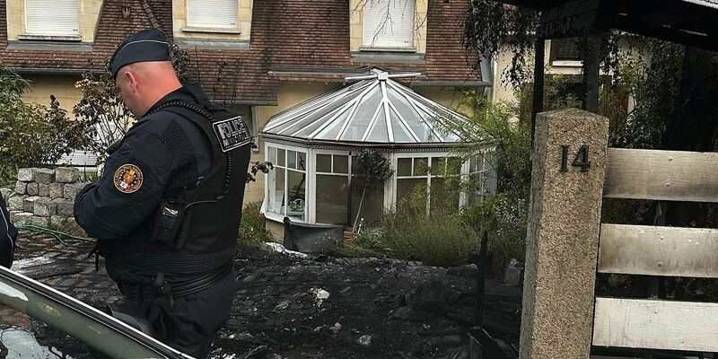 Ein Polizist steht vor dem Haus des Bürgermeisters Vincent Jeanbrun. Randalierer hatten das Haus in der Nacht mit einem Auto gerammt und Feuer gelegt. - Foto: Nassim Gomri/AFP/dpa