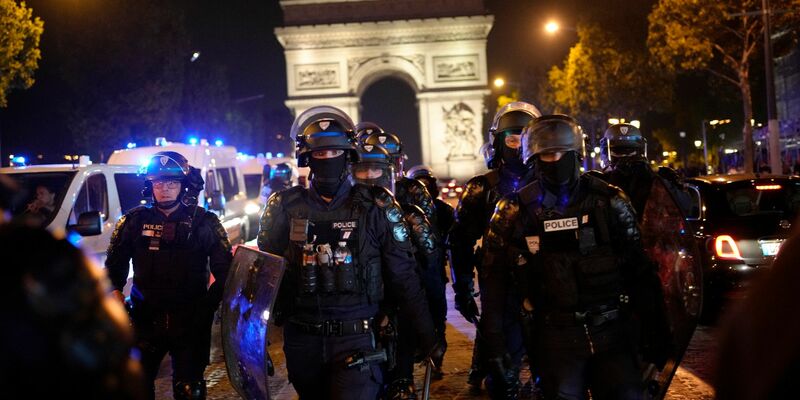 Polizisten patrouillieren vor dem Arc de Triomphe auf den Champs Élysées. - Foto: Christophe Ena/AP