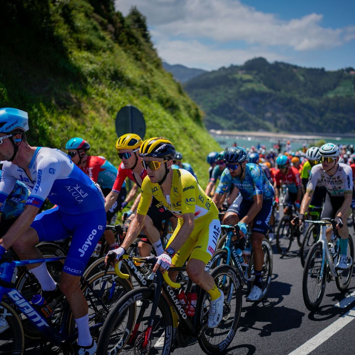 Der Brite Adam Yates (M) bleibt wie erwartet im Gelben Trikot. - Foto: Daniel Cole/AP/dpa
