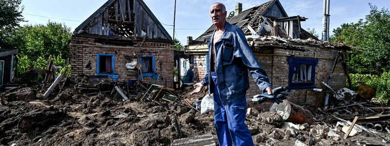 Ein Hausbesitzer begutachtet seinen Hof im Dorf Kuschuhum, in den eine mutmaßlich russische Granate eingeschlagen ist. - Foto: ---/Ukrinform/dpa