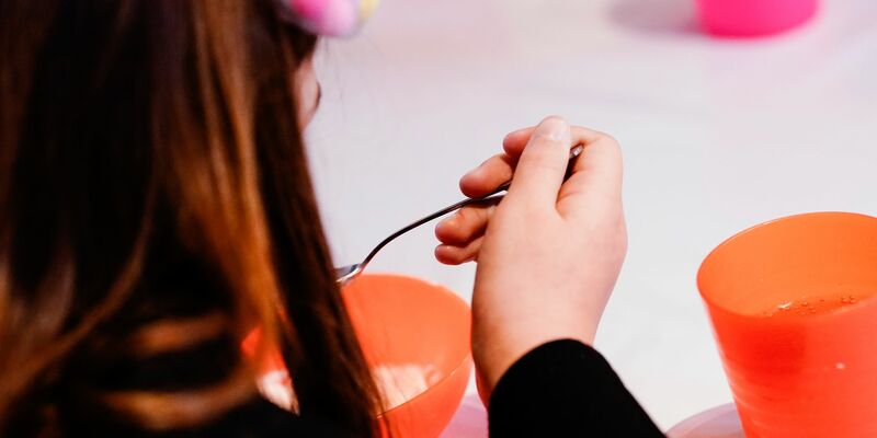 Ein Kind isst bei der Mannheimer Kindervesperkirche (Symbolbild). Laut Familienministerin Paus soll mit der Einführung der Kindergrundsicherung Kinderarmut in Deutschland effektiv bekämpft werden. - Foto: Uwe Anspach/dpa