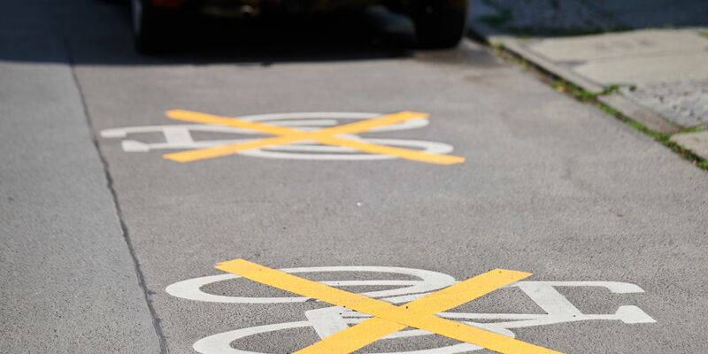 Auf der Ollenhauer Straße sind die Zeichen für den Radweg mit gelben Kreuzen zugeklebt und Autos parken darauf. Der Radweg existiert nicht mehr. - Foto: Annette Riedl/dpa