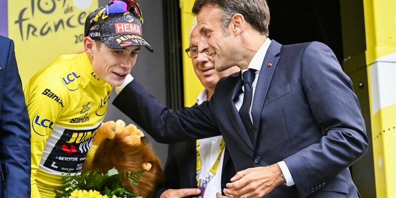 Emmanuel Macron (r), Präsident von Frankreich, gratuliert dem Dänen Jonas Vingegaard im Gelben Trikot des Gesamtführenden auf dem Podium. - Foto: Dirk Waem/Belga/dpa