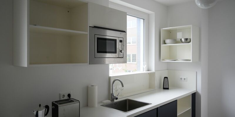 Eine Küche in einem möblierten Wohnraum in einem Neubau. - Foto: Christophe Gateau/dpa