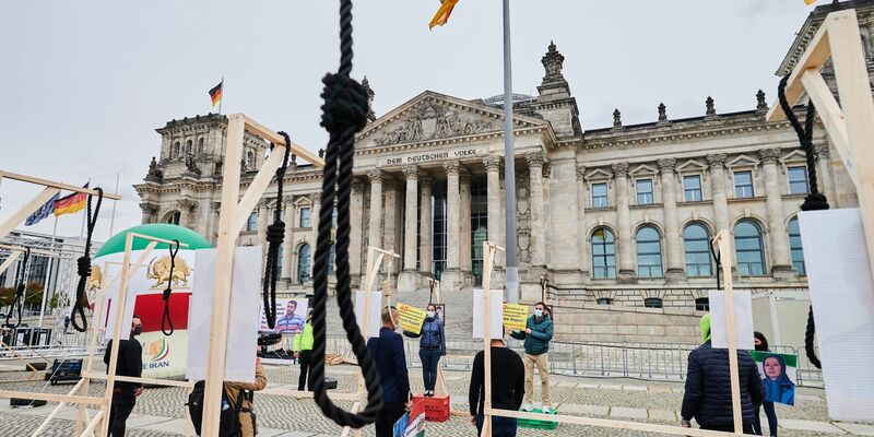 Demonstranten stehen mit symbolischen Galgen vor dem Reichstag und demonstrieren gegen Hinrichtungen und die Todesstrafe im Iran. - Foto: Annette Riedl/dpa/Symbolbild