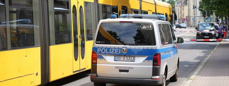 Ein Polizeiauto steht vor der Straßenbahn in Desden, in der ein Mann mit einem Messer attaktiert wurde. - Foto: Benedict Bartsch/xcitepress/dpa