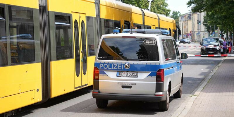 Polizisten stehen in Dresden vor der Straßenbahn, in der es zu der Messerattacke kam. - Foto: Benedict Bartsch/xcitepress/dpa