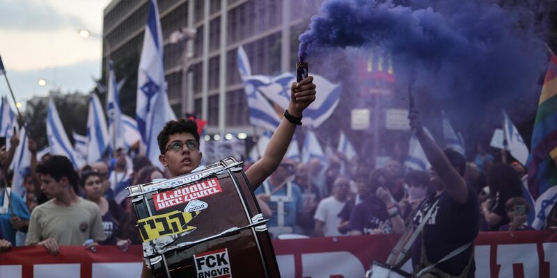 Israelische Demonstranten halten Fahnen und zünden Fackeln während eines Protestes gegen die Pläne der Regierung von Premierminister Netanjahu, das Justizsystem zu reformieren. - Foto: Ilia Yefimovich/dpa