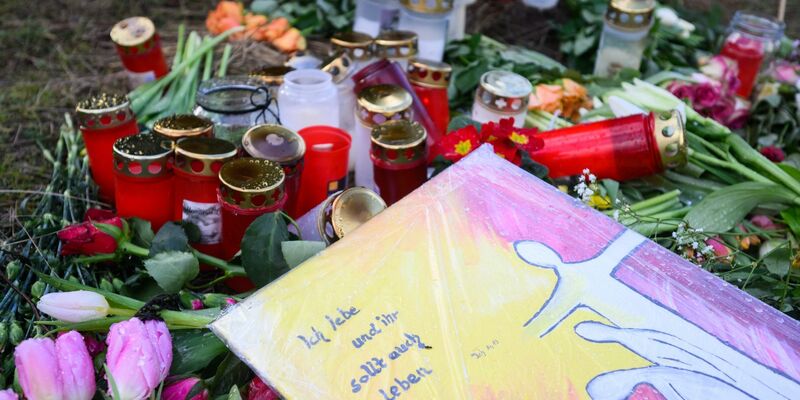 Blumen und Kerzen erinnern in Wunstorf-Blumenau nahe Hannover an den ermordeten 14-jährigen Jungen. - Foto: Julian Stratenschulte/dpa