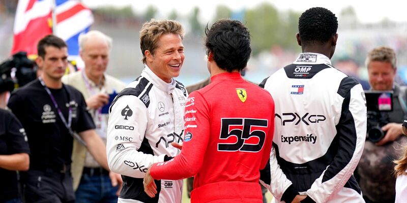 Brad Pitt (l, im Gespräch mit Fahrer Carlos Sainz) und Damson Idris (r) sind auf der Formel-1-Strecke in Silverstone mit von der Partie. - Foto: Tim Goode/PA Wire/dpa