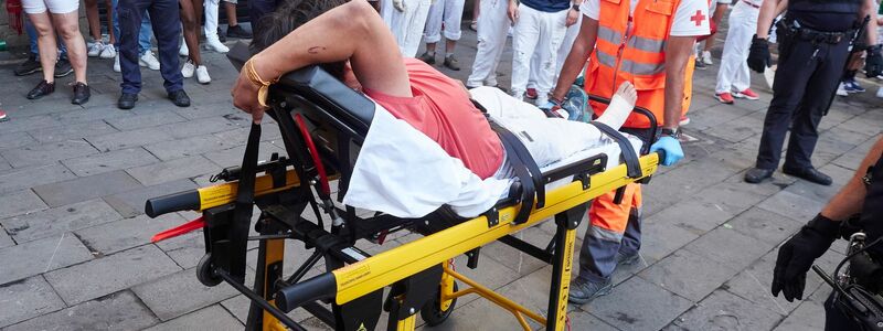 Ein verletzter Mann auf einer Bahre beim  Stiertreiben im spanischen Pamplona. - Foto: Eduardo Sanz/EUROPA PRESS/dpa