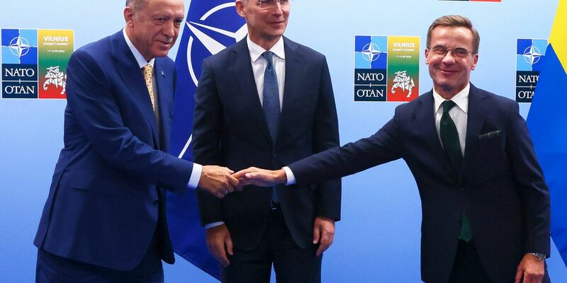 Recep Tayyip Erdogan (l.) und der schwedische Premier Ulf Kristersson (r.) reichen sich im Beisein von Nato-Chef Jens Stoltenberg die Hände. - Foto: Yves Herman/Reuters/AP/dpa