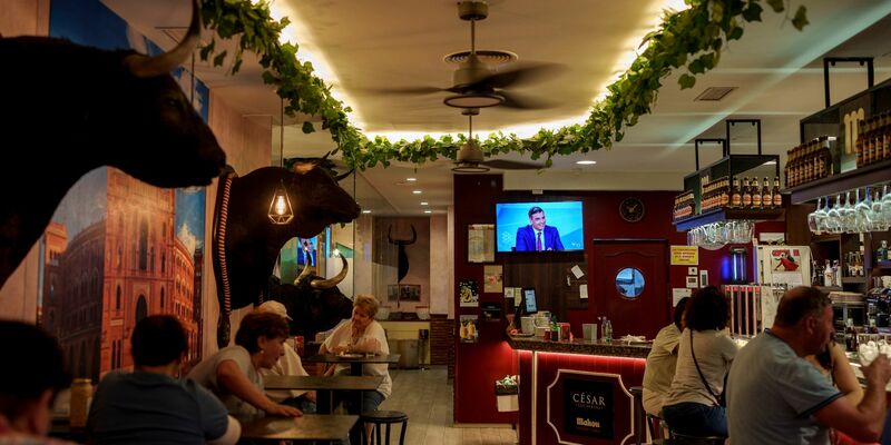 Gäste verfolgen in einer Bar in Madrid die TV-Debatte zwischen Pedro Sánchez und Alberto Núñez Feijóo. - Foto: Manu Fernandez/AP