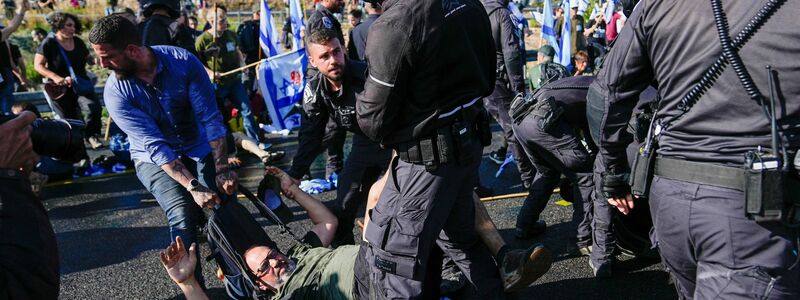 Israelische Polizisten gehen gegen Demonstranten vor, die eine nach Jerusalem führende Straße blockieren. - Foto: Ohad Zwigenberg/AP