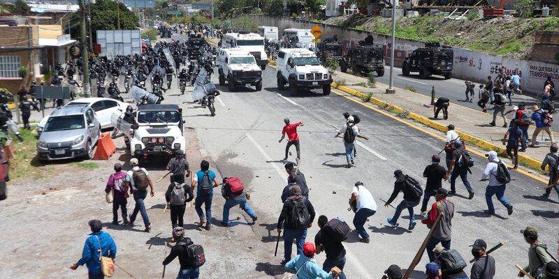 Sicherheitskräfte werden auf einer Autobahn in Chilpancingo von Demonstranten mit Steinen beworfen. - Foto: Eduardo Guerrero Ramirez/dpa