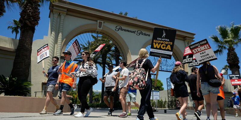 Ein Demonstrant wählt während einer Kundgebung in Los Angeles sein Schild zum Streiken aus. - Foto: Mark J. Terrill/AP