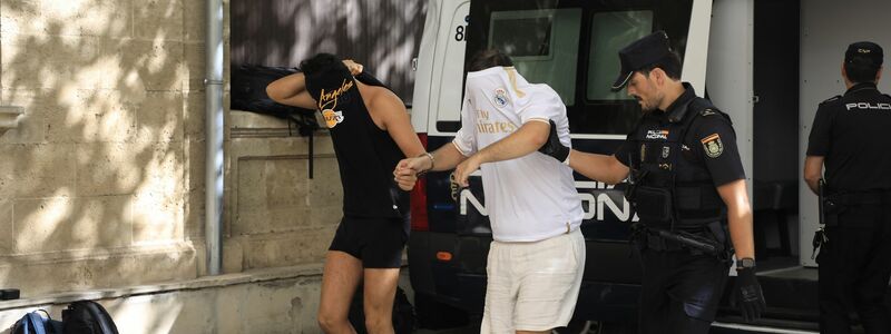 Polizisten führen die Verdächtigen zum Termin mit dem Haftrichter auf Mallorca. - Foto: Clara Margais/dpa