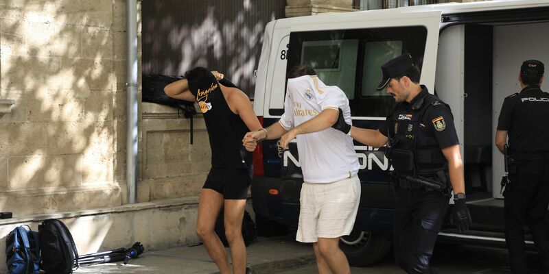 Polizisten führen die Verdächtigen zum Termin mit dem Haftrichter auf Mallorca. - Foto: Clara Margais/dpa