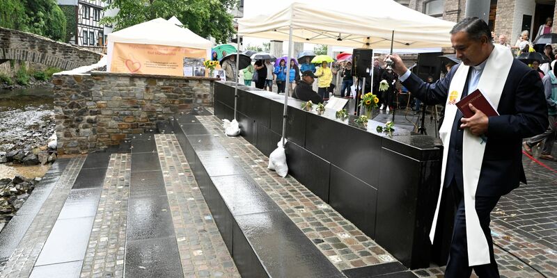 Pfarrer Robert Rego segnet eine Freitreppe an der Erft. - Foto: Roberto Pfeil/dpa