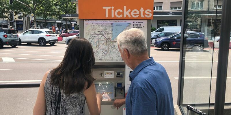 Zwei Leute versuchen, an einem Ticket-Automaten in Genf Fahrkarten zu erwerben. - Foto: Christiane Oelrich/dpa