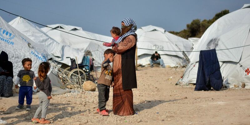 Eine Frau steht mit ihren Kindern im Flüchtlingslager Kara Tepe in der Nähe von Mytilini auf Lesbos (Symbolbild). - Foto: Panagiotis Balaskas/AP/dpa