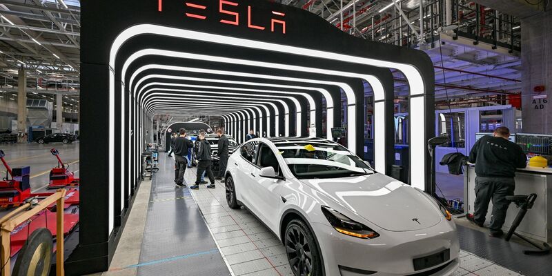 Mitarbeiter der Tesla Gigafactory Berlin Brandenburg arbeiten an der Endkontrolle der fertigen Elektrofahrzeuge vom Typ Model Y. - Foto: Patrick Pleul/dpa