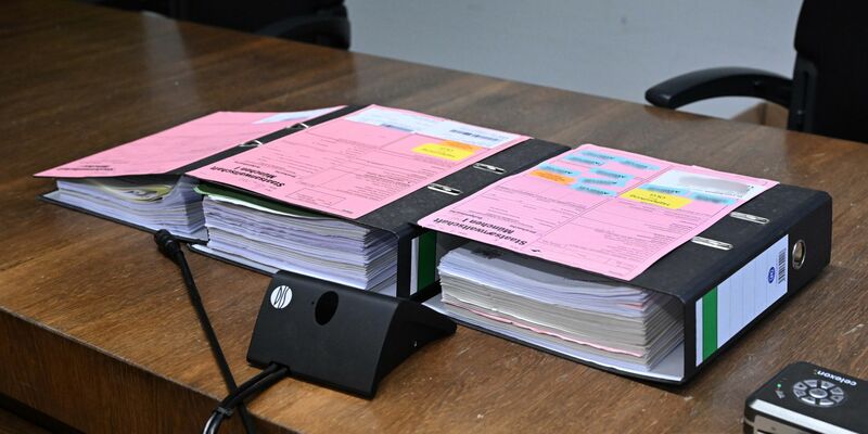 Akten liegen beim Auftakt im Prozess zu einem Mord in einer psychiatrischen Klinik im Sitzungssaal im Landgericht München I. - Foto: Felix Hörhager/dpa