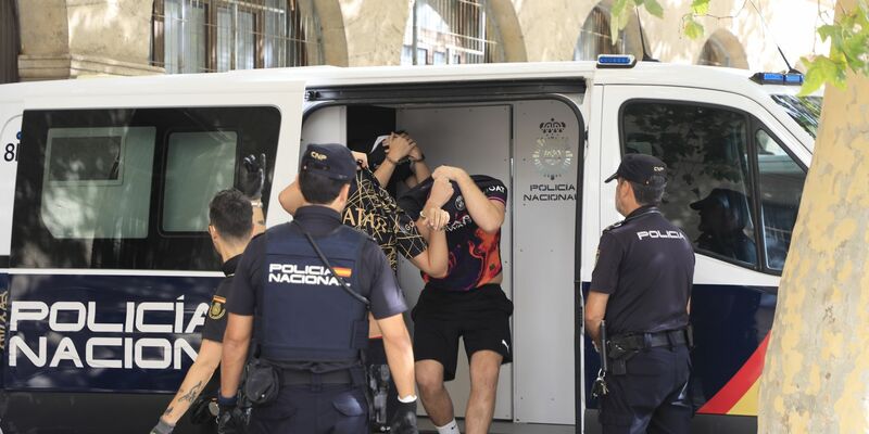 Polizisten führen die Verdächtigen zum Termin mit dem Haftrichter auf der Balearischen Insel. - Foto: Clara Margais/dpa
