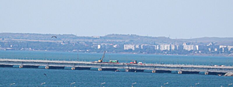 Ein russischer Militärhubschrauber überfliegt die beschädigten Teile der Automobilverbindung der Krim-Brücke. - Foto: -/AP/dpa