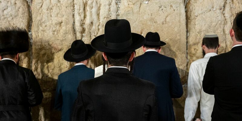 Ultraorthodoxe jüdische Männer beten an der Klagemauer. - Foto: Christophe Gateau/dpa