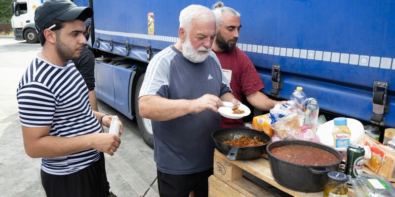 Die Lastwagenfahrer an der südhessischen Autobahnraststätte haben eine Palette  zu einem provisorischen Tisch für ihr Abendbrot umfunktioniert. - Foto: Boris Roessler/dpa