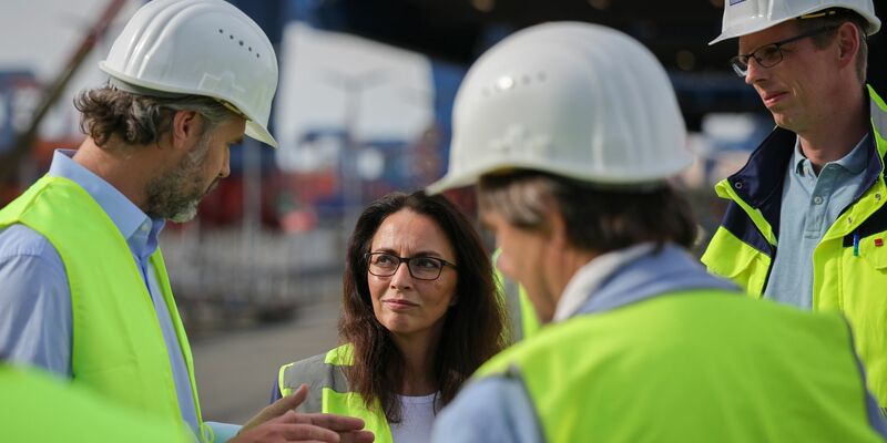 Yasmin Fahimi, Vorsitzende des Deutschen Gewerkschaftsbundes (DGB), im Gespräch bei der Hamburger Hafen und Logistik AG (HHLA) im Rahmen ihrer Sommertour auf dem Containerterminal Altenwerder CTA. - Foto: Christian Charisius/dpa