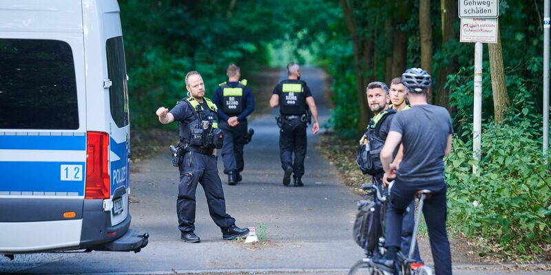 Polizisten stehen am Eingang eines Waldgebietes in dem sich die Raubkatze befinden soll. - Foto: Annette Riedl/dpa