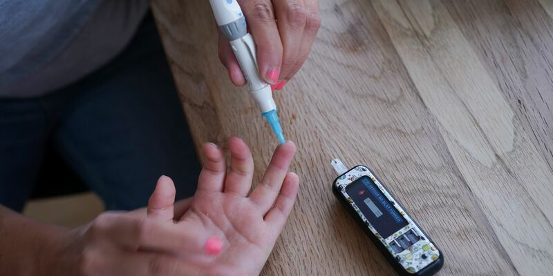 Dem vierjährigen Oskar wird von seiner Mutter der Blutzuckergehalt gemessen. - Foto: Jörg Carstensen/dpa