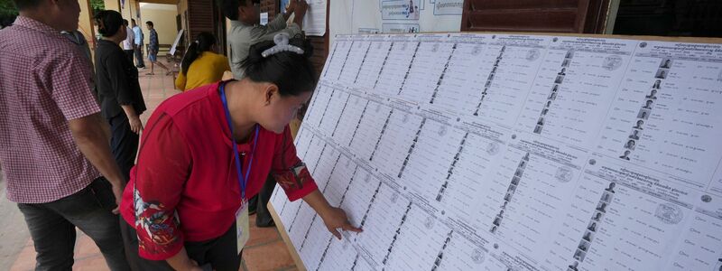 Bewohner von Phnom Penh sehen sich vor der Stimmabgabe in einem Wahllokal eine Registrierungsliste an. - Foto: Heng Sinith/AP