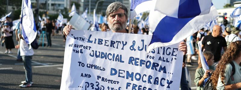 Dieser Demonstrant in Tel Aviv gehört zu den Unterstützern des Gesetzesvorhabens. - Foto: Ilia Yefimovich/dpa